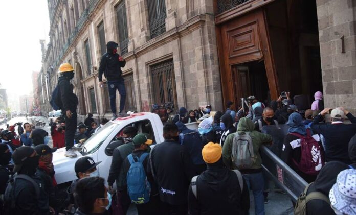 Vandalizan normalistas una puerta de Palacio Nacional